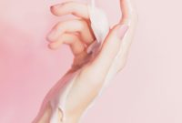 Wallpaper A Woman’s Hand Holding a Lotion Bottle
