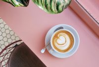 Wallpaper Cup of Coffee on Saucer with Teaspoon on Pink Tabletop
