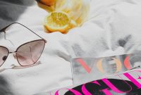 Wallpaper A Pair of Sunglasses and a Book on a Bed