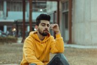 Wallpaper Man in Yellow Hoodie and Blue Denim Jeans Sitting on Brown Concrete Bench