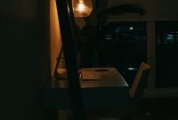 Wallpaper A Dark Room with a Desk and a Lamp