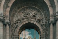 Wallpaper A Large Arched Doorway with a Gold Door and Gold Cross