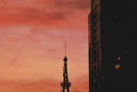 Wallpaper A Tall Tower Piercing a Cloudy Sky