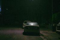 Wallpaper A Car Parked on the Side of the Road at Night