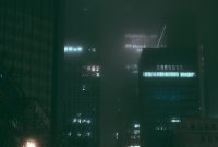 Wallpaper A City Street at Night with Tall Buildings