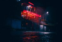 Wallpaper A Building with Red Lights at Night