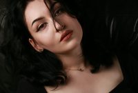 Wallpaper A Woman Sitting on a Couch with Her Eyes Closed