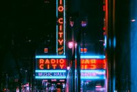 Wallpaper A City Street at Night with a Radio City Sign
